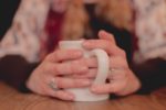 close up of woman holding a coffee cup