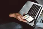 Person using a laptop and mobile phone