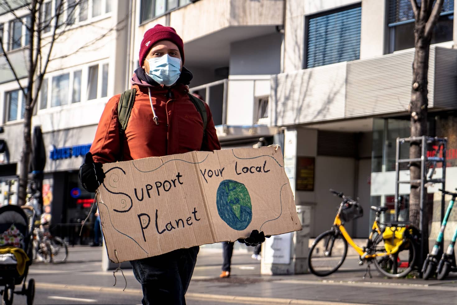 man with banner reading support your local planet