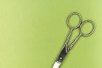 pair of silver scissors on green background