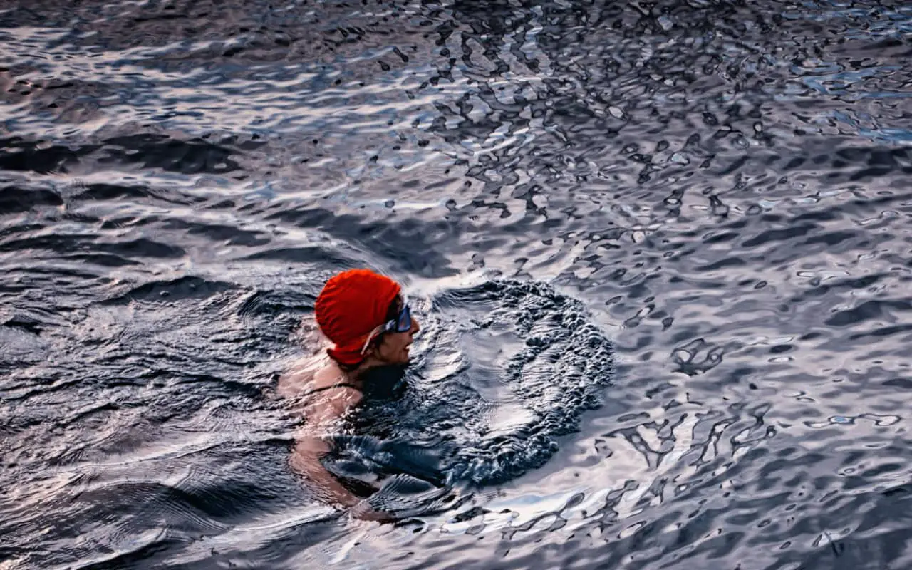 Cold water swimmer with a red swimming cap