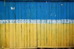 Ukrainian flag colours painted on wooden fence