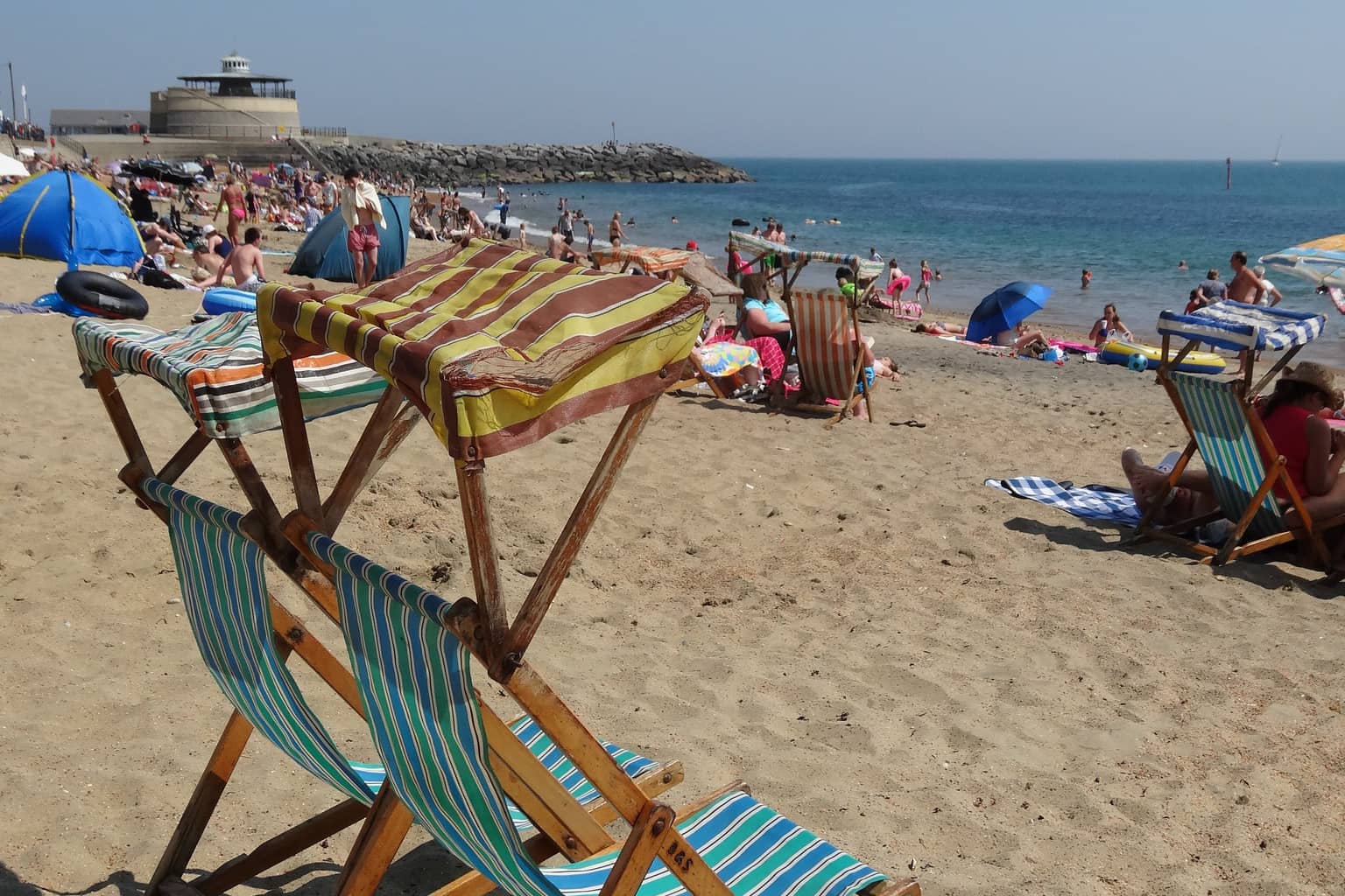 People and deck chairs on Ventnor beach in the summer