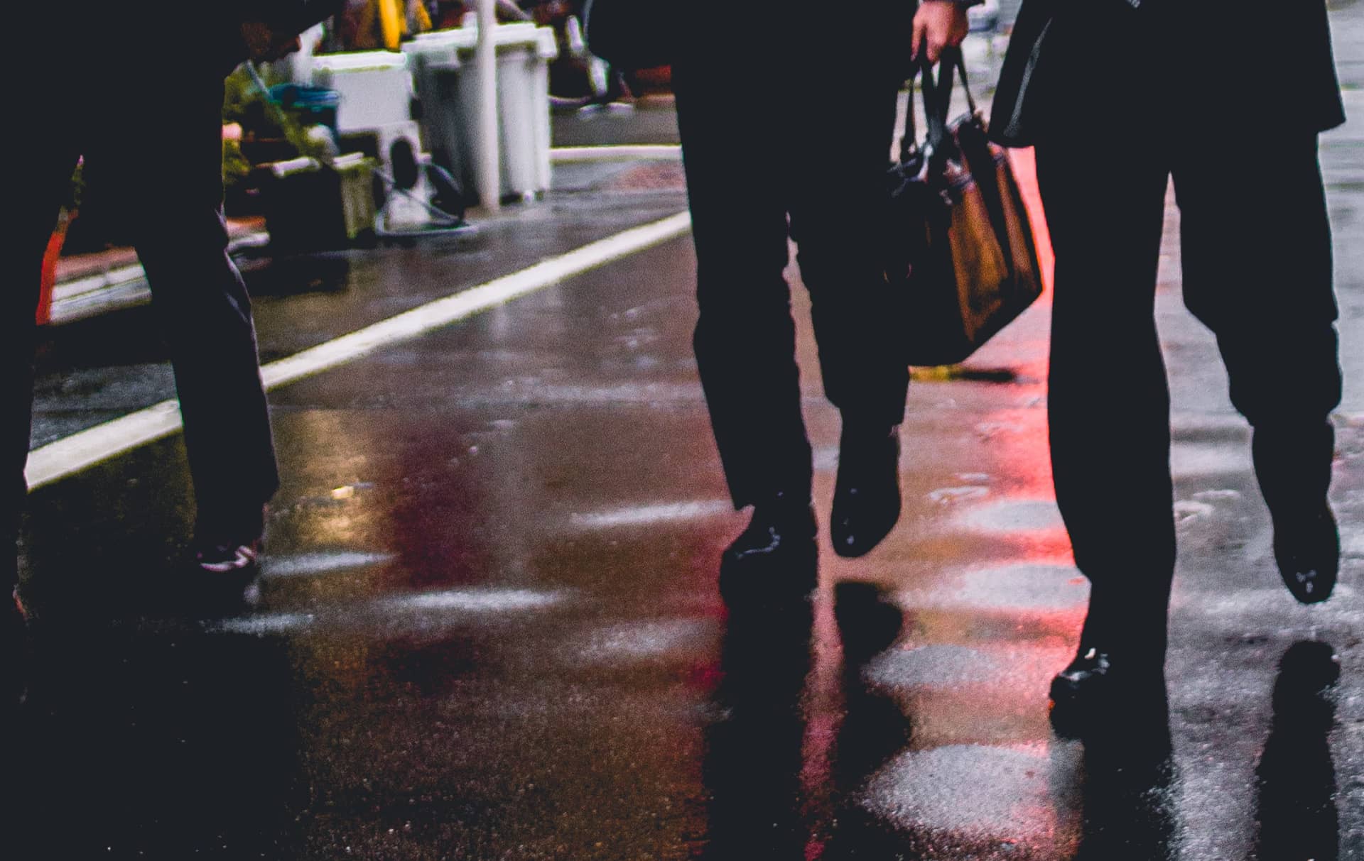 businessmen walking down a wet street