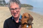 Jonathan Bacon and his dog on the beach