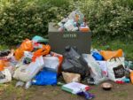 Bags of rubbish by a kerb side bin