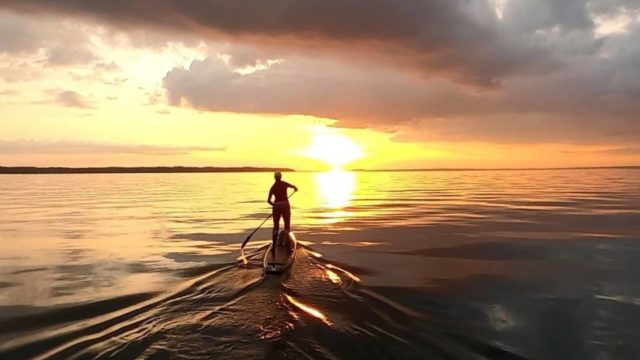 Emily on paddleboard in sunset