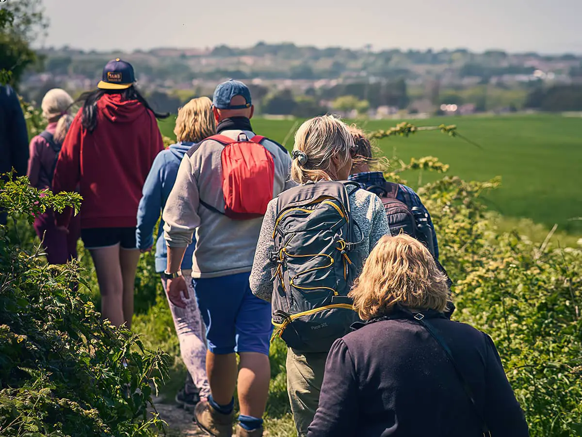 Backs of people walking as part of the Isle of Wight Spring Walking Festival 2022