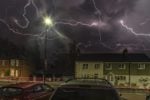 Lightning show above houses at night