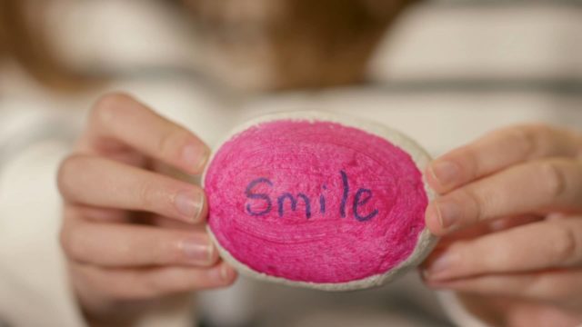 Smile message painted on a pebble