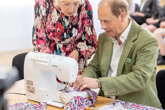Margaret Loveridge showing Prince Edward how to use the sewing machine