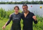 Jessica and David in wet suits by the water