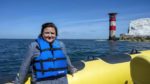 Susan Calman on a boat with Needles in background