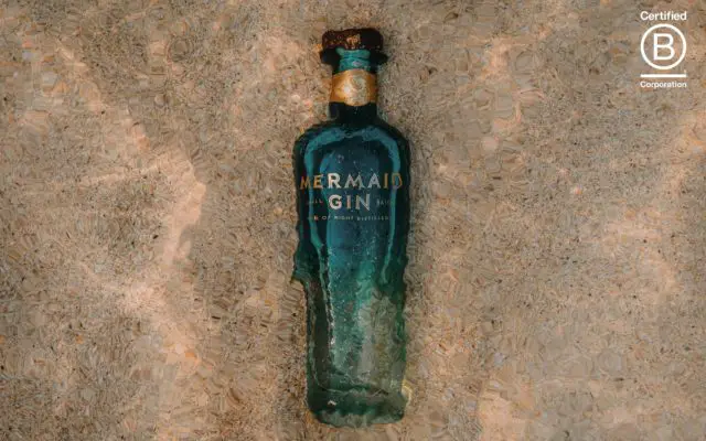 Bottle of Mermaid gin under water with b-corp logo