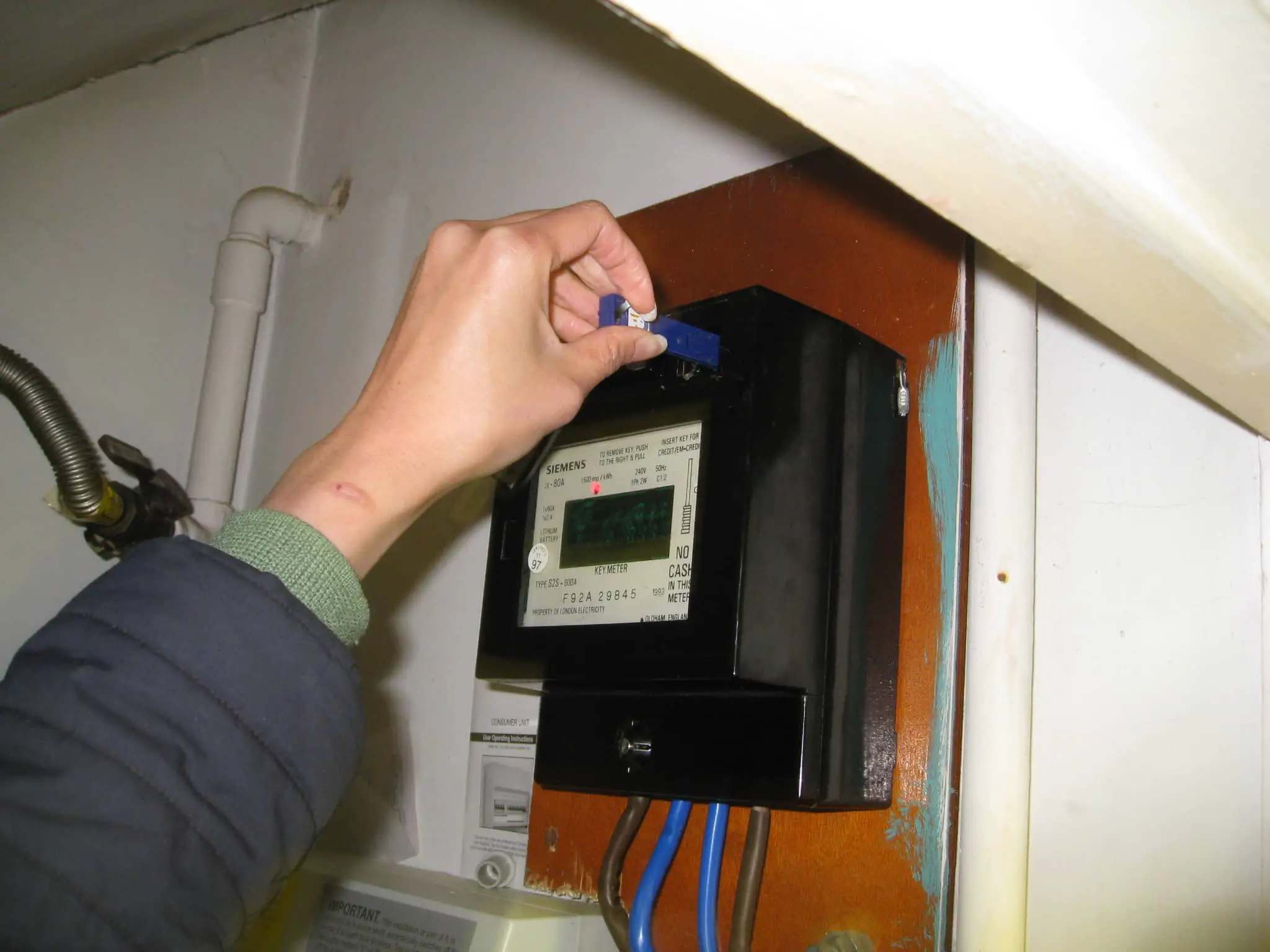 Person putting an Electricity key into a meter