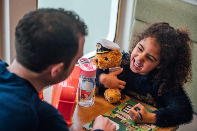 Girl with Red Funnel teddy smiling at her Dad