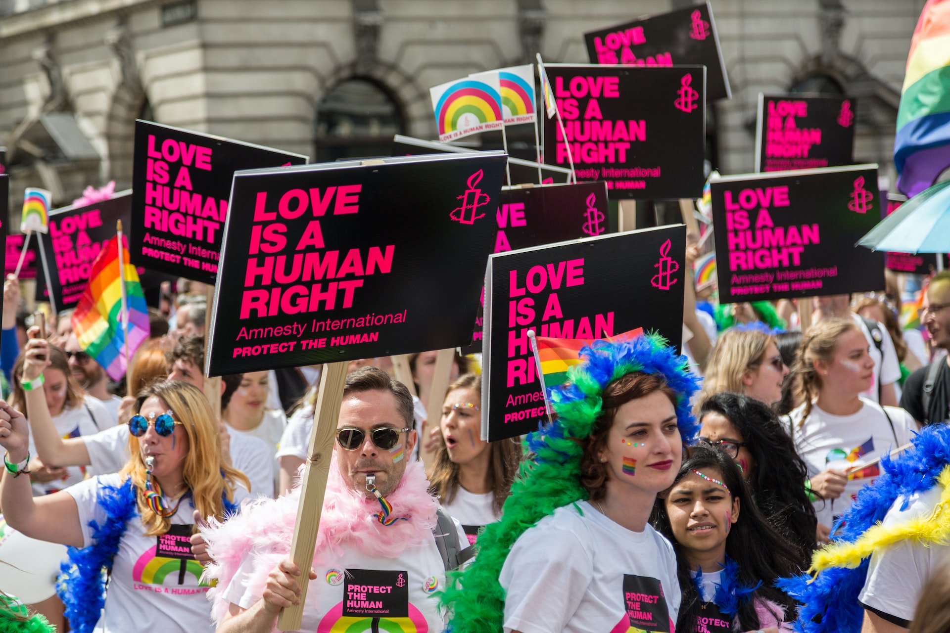 People at Pride march with banners reading ' love is a human right'