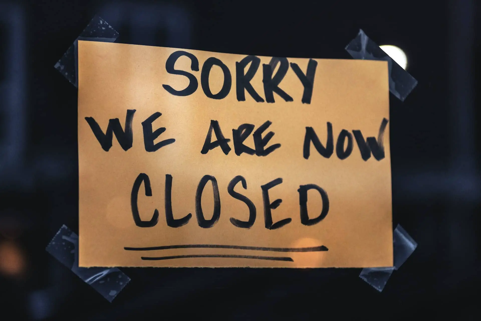 sign reading 'sorry we are now closed' on shop door