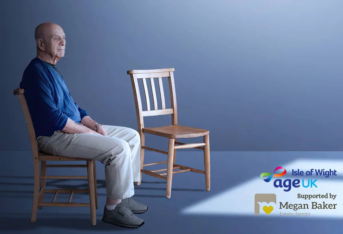 Older man sitting on chair next to an empty chair as part of the Age UK Isle of Wight no-one should have no-one campaign