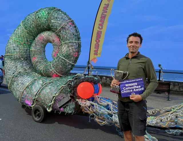 Eco-artist Glenn Martin with his illuminated sculpture made from plastic found on local beaches - Sandown Carnival