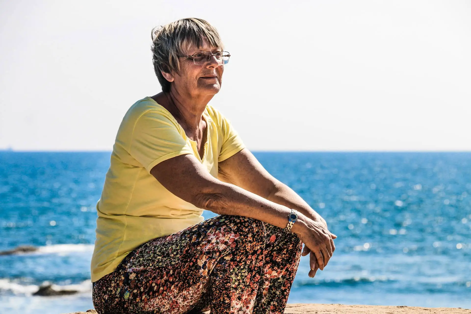 Older woman sitting on the beach