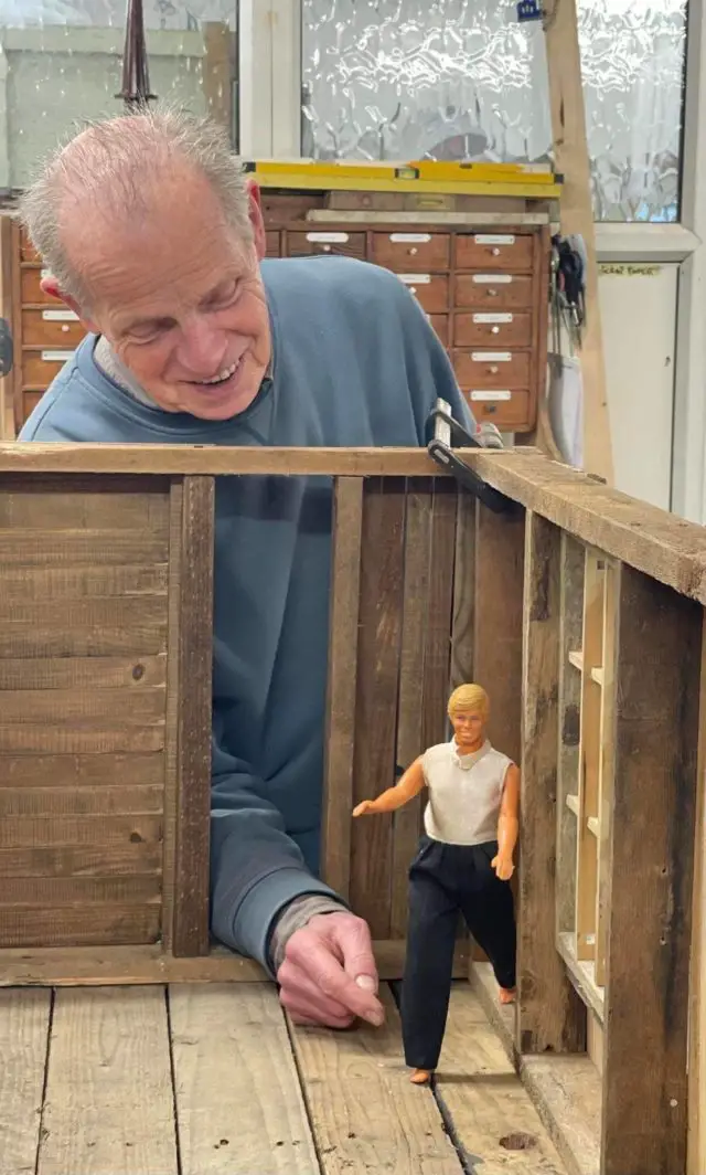 Phil Warren with scale model of Olivia Parkes' home on stilts 