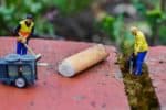 Tiny models of litter pickers next to cigarette butt