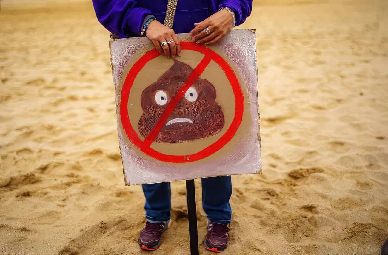 Person with poo placard on the beach