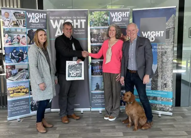 Brighstone Youth FC – Two representatives of Brighstone Youth FC receive their donation from Nicola Young (Wine Therapy) and Geoff Underwood.