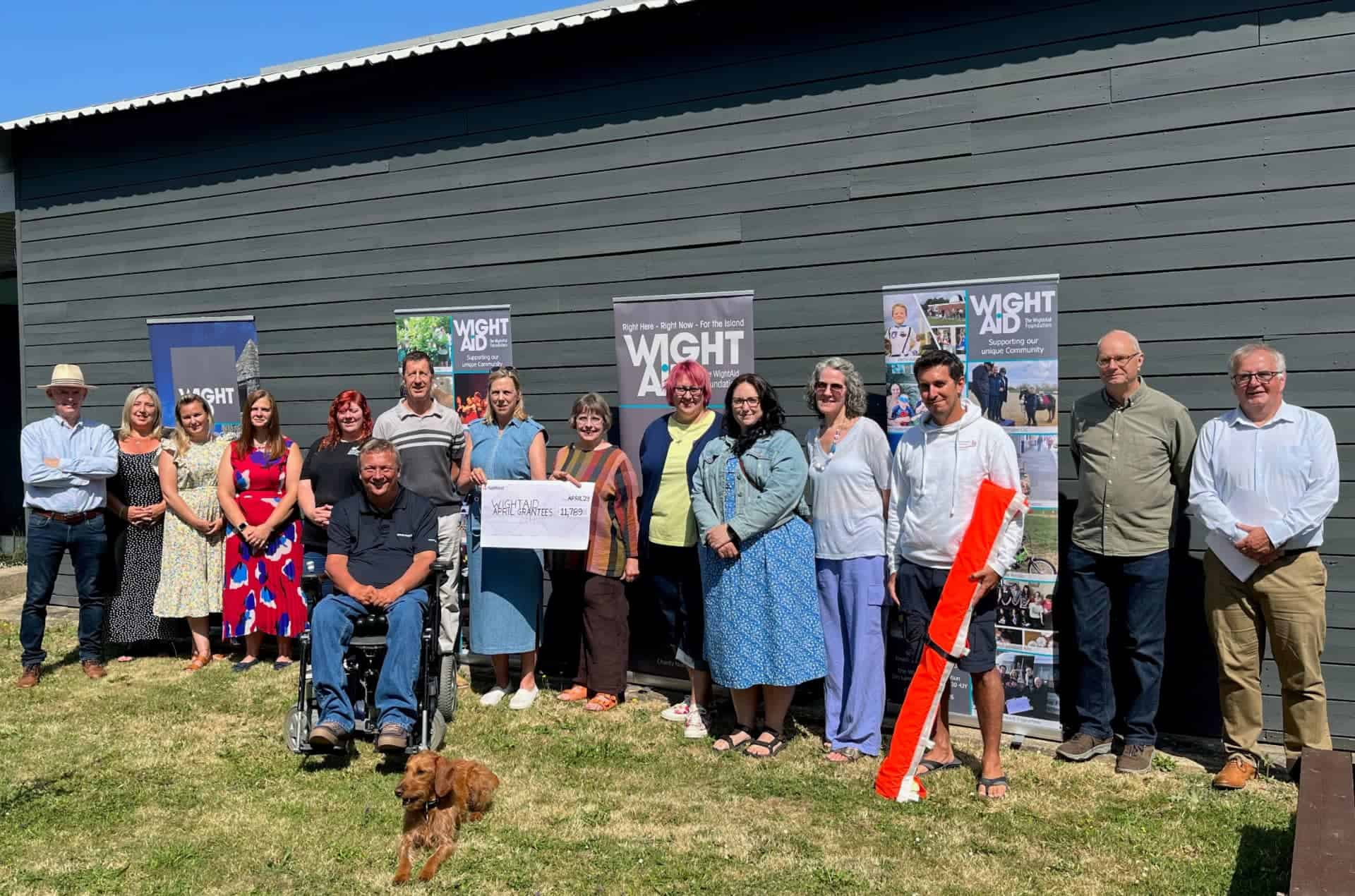 WightAID donors Marianne And Richard Atterbury presenting a cheque with representatives of the charities and WightAID trustees…and Mavis the dog!