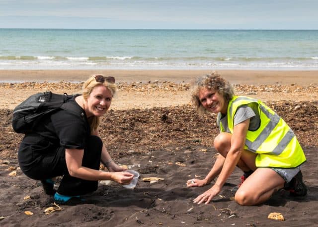 Island visitor, Sally Meadows and Planet Aware volunteer Susanna Dean searching for nurdles on the beach.