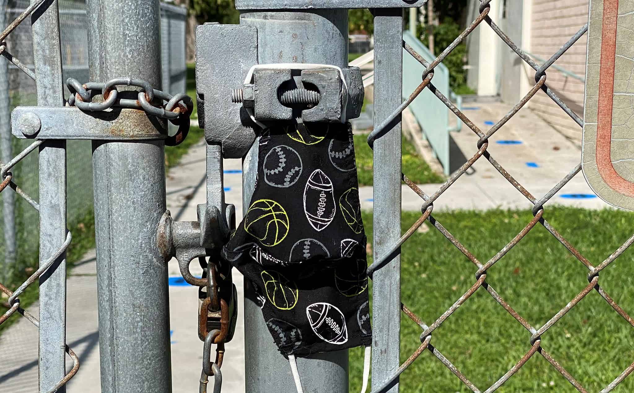 School gates locked with childs face mask