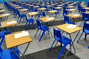 desks and chairs set up in a hall ready for exams