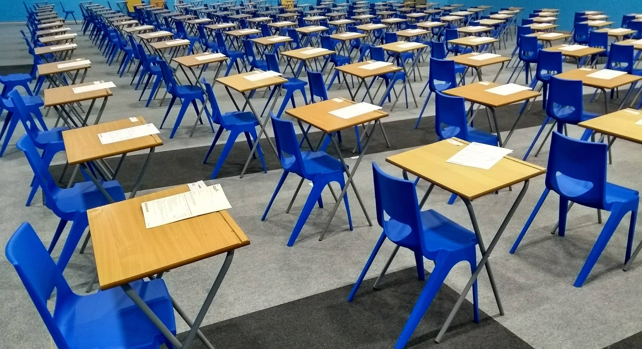 desks and chairs set up in a hall ready for exams
