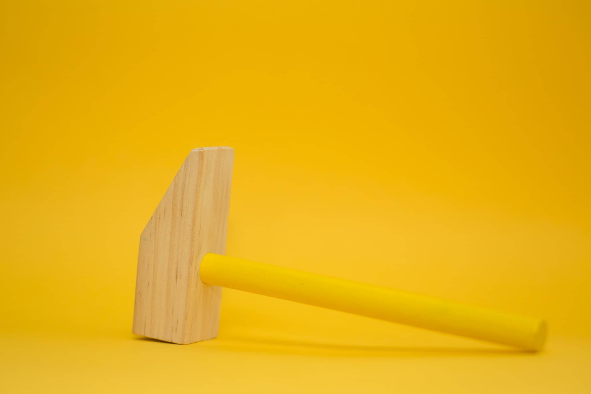 yellow background with wooden hammer