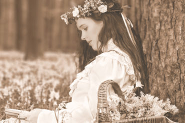 Woman in Victorian clothes reading under a tree - image used on the Book cover of Arresting Beauty