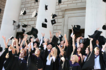 Uni graduates throwing their mortar boards in the air