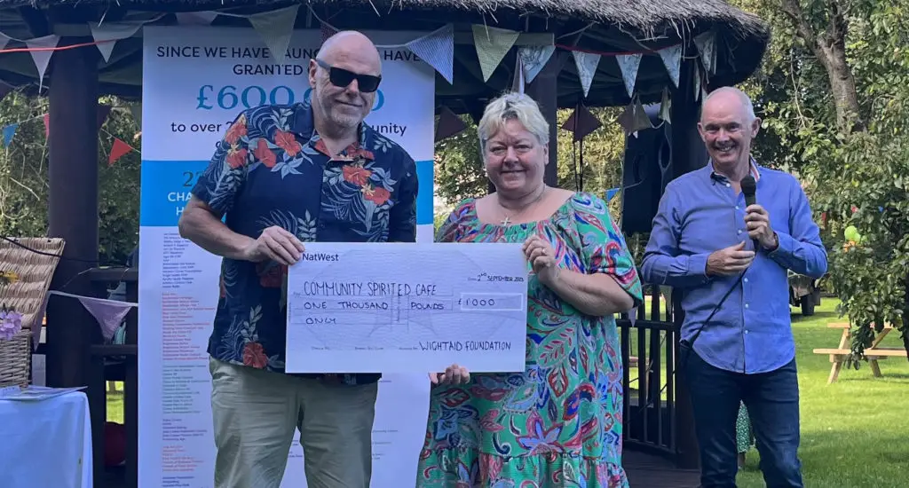 John Irvine, CEO of Wightfibre, presents a cheque for £1,000 to Jane Allchorn of Community Spirited Café