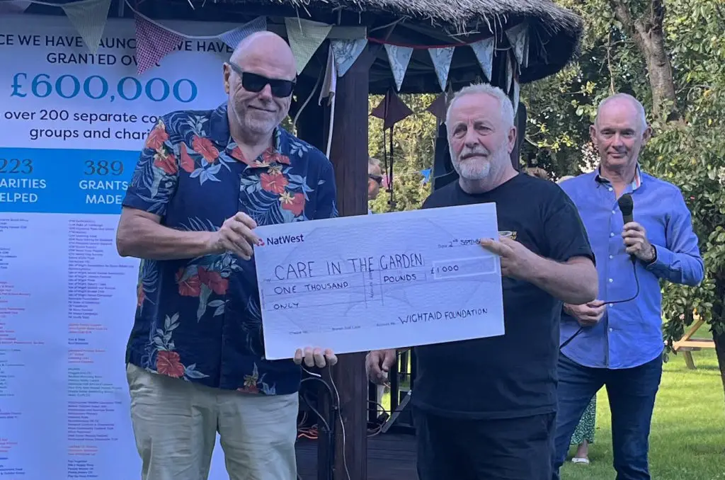 John Irvine, CEO of Wightfibre, presents a cheque for £1,000 to John Goodenough, of Care In the Garden