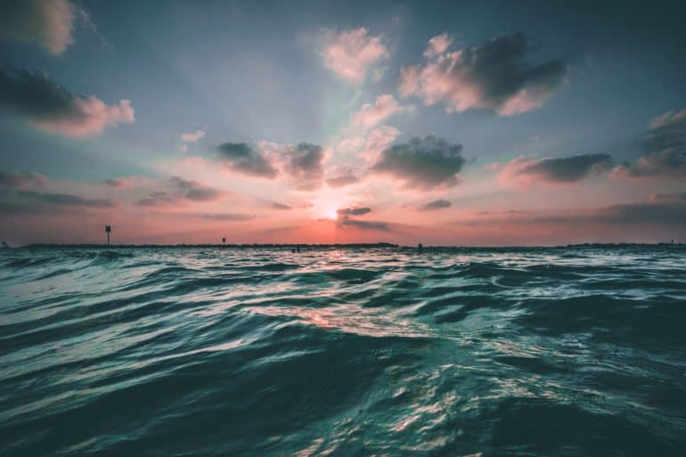 Point of view of someone in the sea looking out to the sunset