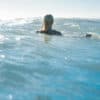 Woman in the sea with a wet suit on