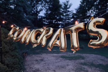 Gold balloon hanging in garden saying congrats