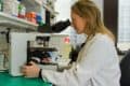 female scientist looking in microscope