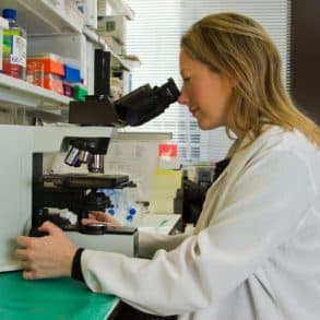 female scientist looking in microscope