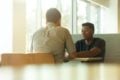 two men talking at a table by linkedin sales solutions