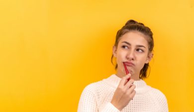 woman brushing her teeth on yellow background by diana polekhina