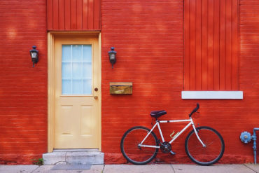 Front door of house with bicycle leaning up against the wall