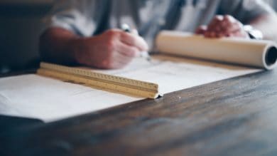 Man drawing on architectural blueprints