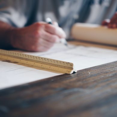 Man drawing on architectural blueprints