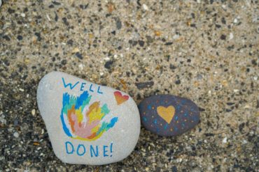 Pebbles painted with well done messages